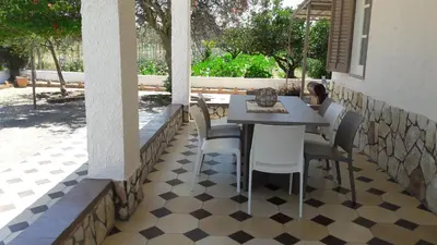 a patio with a table and chairs on a checkered floor at Casa Vacanze Reginotte in Balestrate