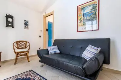 a black leather couch in a living room with a chair at Villa Mare Ficarazzi in Ficarazzi
