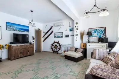 a living room with a couch and a tv at Villa Mare Ficarazzi in Ficarazzi