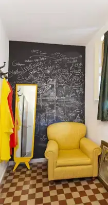a bedroom with a bed and a chair and a mirror at Casa pergj in Palermo