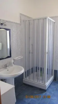 a bathroom with a glass shower and a sink at La sterlizia in Mondello