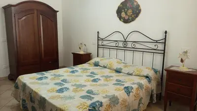 a bedroom with a bed with a floral bedspread at Appartamento Nino in San Vito lo Capo