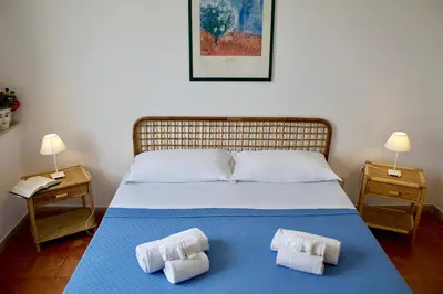 a bedroom with a bed with two towels on it at Villa Casa Madre in San Vito lo Capo