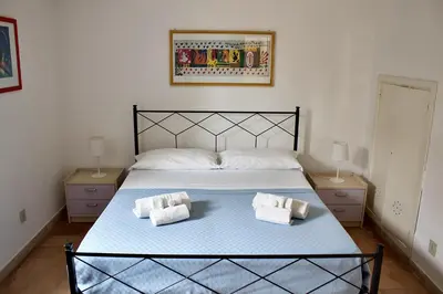 a bedroom with a large bed with two pillows on it at Villa Casa Madre in San Vito lo Capo
