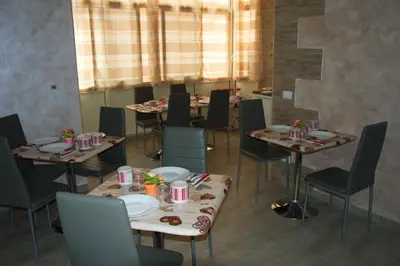 a dining room with tables and chairs and a window at B&B Palermo Sole & Cultura in Palermo