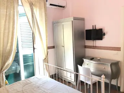 a bedroom with a bed and a desk and a tv at B&B Dimora Annulina in Palermo