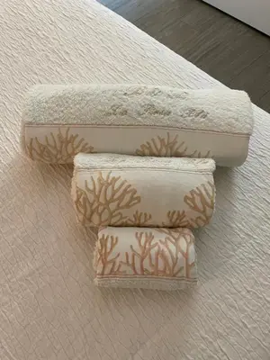 three towels sitting on top of a bed at La Rosa Blu in San Vito lo Capo