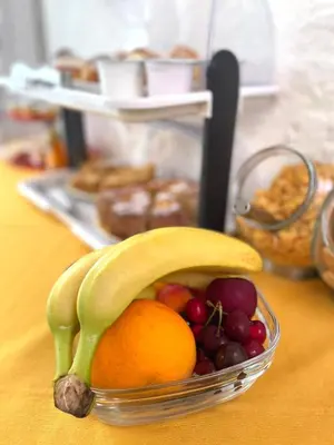 a bowl of fruit with a banana and oranges at La Rosa Blu in San Vito lo Capo
