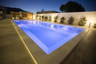 a large swimming pool in a house at night at Villa Del Mare in Alcamo Marina