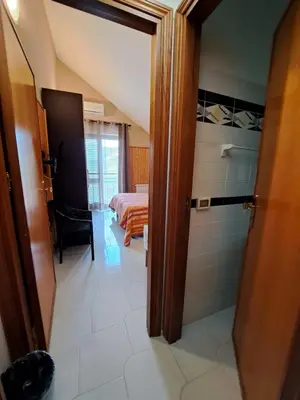a bathroom with a shower and a bedroom with a bed at Kairos B&B in San Giuseppe Jato