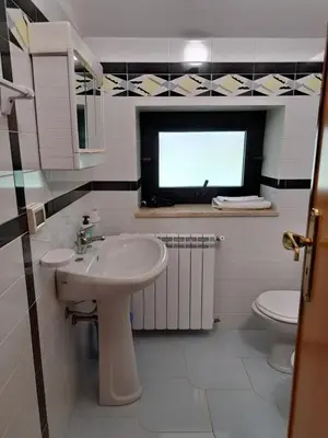 a bathroom with a sink and a toilet and a window at Kairos B&B in San Giuseppe Jato