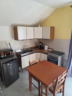 a kitchen with a table and a sink and a stove at Kairos B&B in San Giuseppe Jato