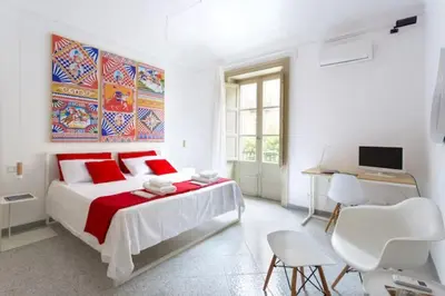 a white bedroom with a large bed and a desk at COLORI di PALERMO in Palermo