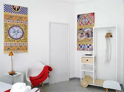 a white room with a chair and a painting on the wall at COLORI di PALERMO in Palermo
