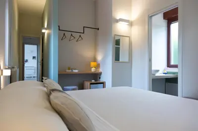 a bedroom with a white bed and a bathroom at Mondello Martini in Mondello