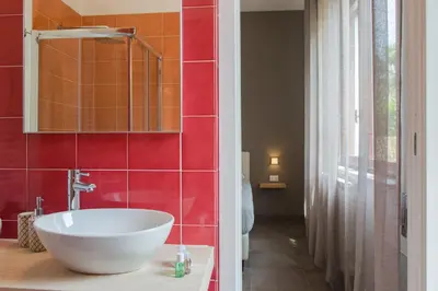 a bathroom with a white sink and red tiles at Mondello Martini in Mondello