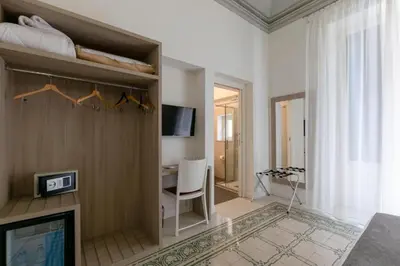 a man standing on a bed with a book and towels at Belmonte102 Esclusive Suites in Palermo