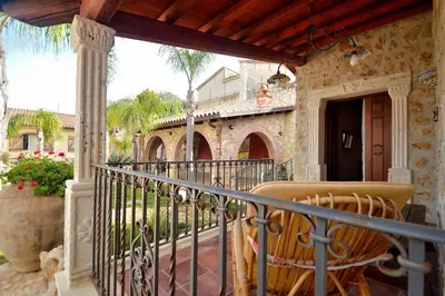 a balcony with a table and chairs on a house at Dependence Desiree in Alcamo