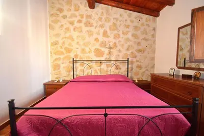 a bedroom with a bed with a pink bedspread at Dependence Desiree in Alcamo