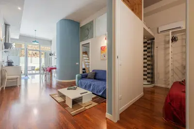 a living room with a blue couch and a table at Sacra Famiglia Ausonia Apartment in Palermo