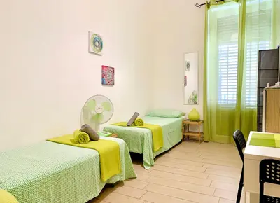 a room with two beds with yellow and green at Bruno and Breakfast in Palermo