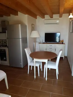 a kitchen with a table and chairs and a refrigerator at Suite Panoramic in Porticello