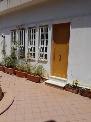a brown door on a white building with plants at Suite Panoramic in Porticello
