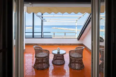a room with a table and chairs and a view of the ocean at Vero Sicily - Villa San Giorgio in Cinisi