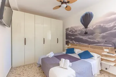 a bedroom with a bed with a painting on the wall at Maison Brigitte - Solemar Sicilia in Santa Flavia