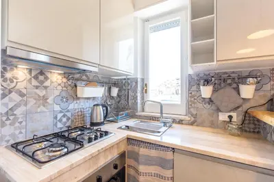 a kitchen with a stove and a sink at Maison Brigitte - Solemar Sicilia in Santa Flavia