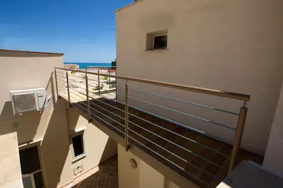 a balcony of a building with a view of the ocean at 4Canti Case Vacanze in Castellammare del Golfo