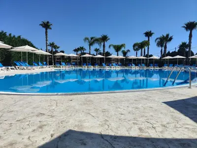 a large swimming pool with chairs and umbrellas at Residence Hydria in Campofelice di Roccella