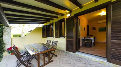a dining room with a table and chairs on a patio at Residence Hydria in Campofelice di Roccella
