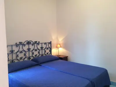 a bedroom with a blue bed with a blue blanket at villa Anna Silvia Makari fiction rai 1 Casa Saverio La Manna in San Vito lo Capo