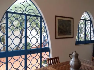 a dining room with a table and a stained glass window at villa Anna Silvia Makari fiction rai 1 Casa Saverio La Manna in San Vito lo Capo