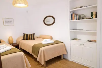 a bedroom with two beds and a book shelf at Palazzo Moncada Apartment in Palermo