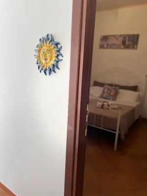 a room with a bed and a clock on the wall at Il Cortile in San Vito lo Capo