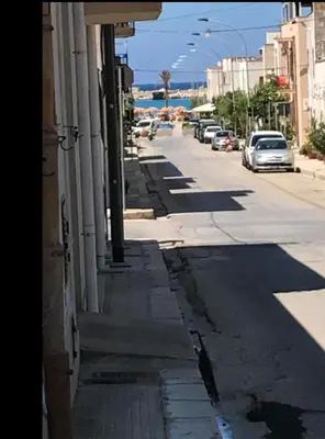 an empty street with cars parked on the side of a building at Il Cortile in San Vito lo Capo