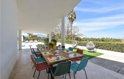 a dining table and chairs on a patio at Villa Delle Sterlizie in Valguarnera
