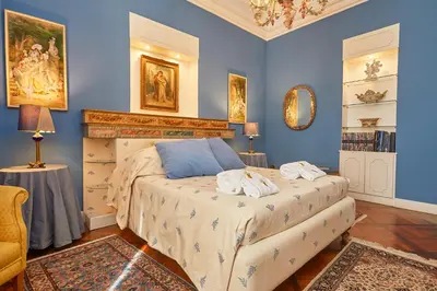 a bedroom with blue walls and a bed with towels on it at Dimora dei Leoni in Palermo
