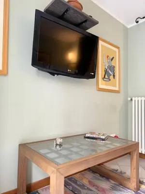 a tv hanging on a wall above a coffee table at Voile Rouge in Palermo