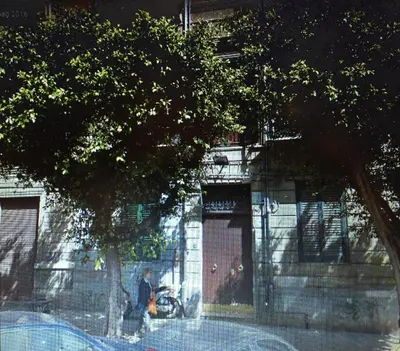 a person walking down a street in front of a building at Voile Rouge in Palermo