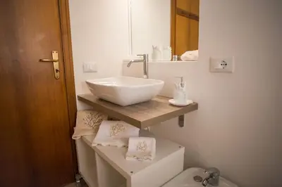 a bathroom with a white sink and a toilet at Villa sul mare in Palermo