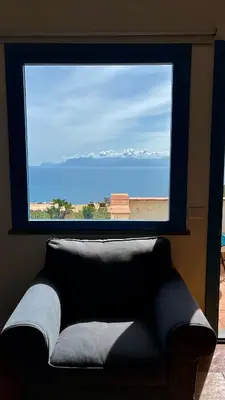 a window in a room with a couch looking out at the ocean at Casa di Cri in San Vito lo Capo