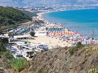 a beach with a bunch of umbrellas and the ocean at casa Barone in Balestrate