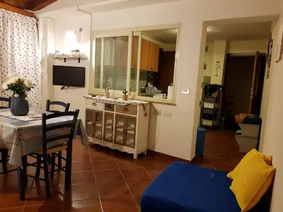 a living room with a table and a blue couch at casa Barone in Balestrate