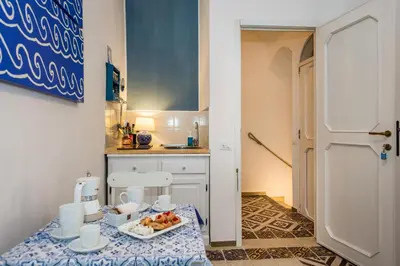 a kitchen with a table with a plate of fruit on it at Le Maioliche in Castellammare del Golfo