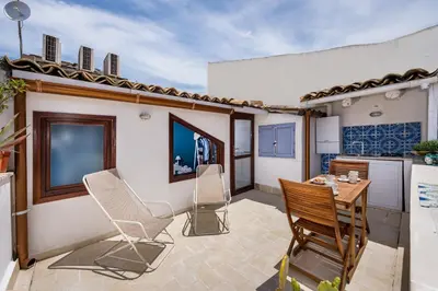 a patio with chairs and a table and a kitchen at Le Maioliche in Castellammare del Golfo
