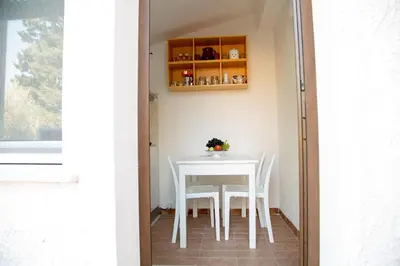 a table and chairs on a patio with a window at Villino Fraginesi in Castellammare del Golfo