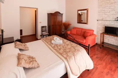a bedroom with two beds and a red couch at Hotel Concordia in Palermo
